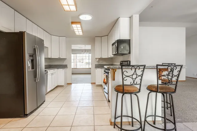 a kitchen with stainless steel appliances granite countertop a refrigerator and a stove top oven