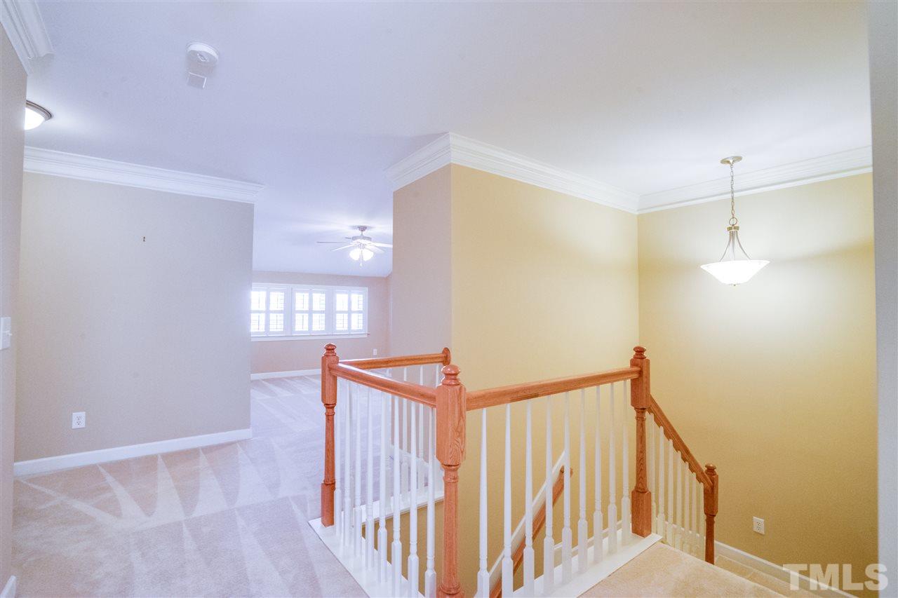 2303 Dunlin Lane Raleigh, NC 27614 - Photo 12 of 25 a view of a hallway to a room with stairs and wooden floor