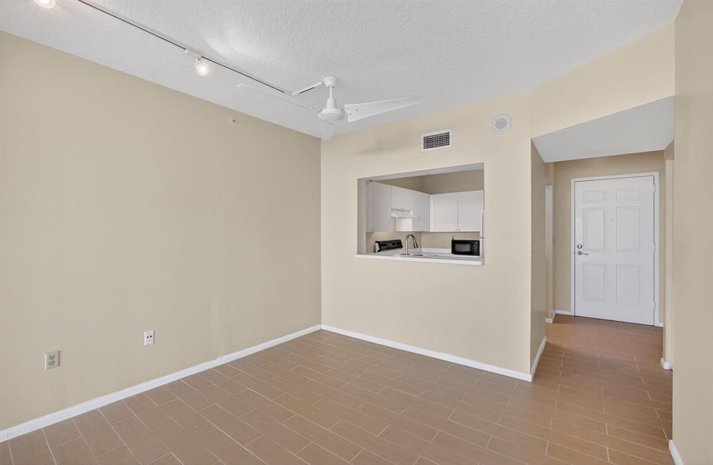 3020 Northeast 32nd Avenue, Unit 819 Fort Lauderdale, FL 33308 - Photo 14 of 68 a view of a room with wooden floor and a kitchen