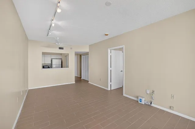 an empty room with windows and fan