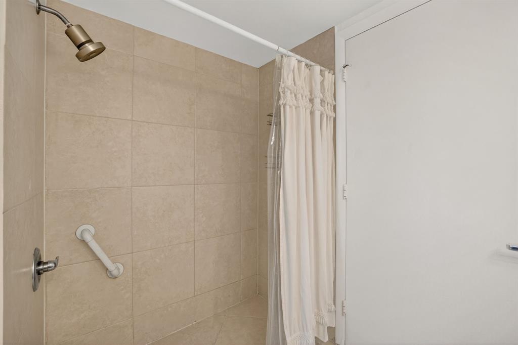 3020 Northeast 32nd Avenue, Unit 819 Fort Lauderdale, FL 33308 - Photo 25 of 68 a bathroom with a shower and a shower curtain