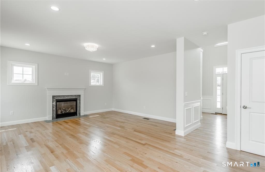 106 Rock Ridge Road Manchester, CT 06040 - Photo 5 of 19 an empty room with wooden floor fireplace and windows