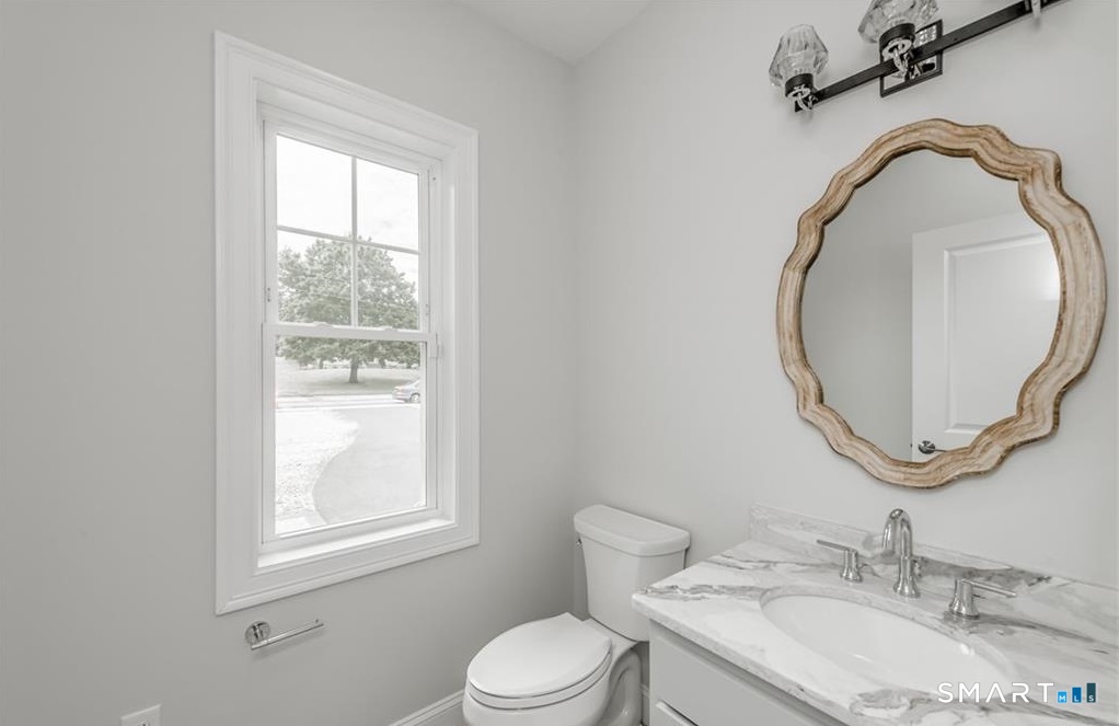 106 Rock Ridge Road Manchester, CT 06040 - Photo 7 of 19 a bathroom with a granite countertop toilet a sink and mirror
