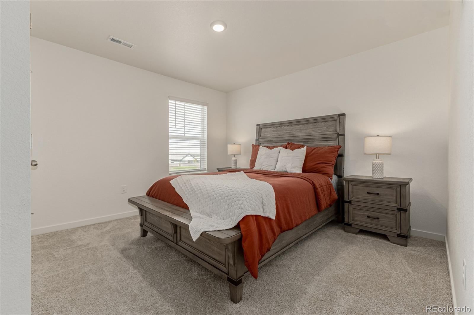 773 Allium Street Watkins, CO 80137 - Photo 24 of 46 a bed sitting in a bedroom next to a window