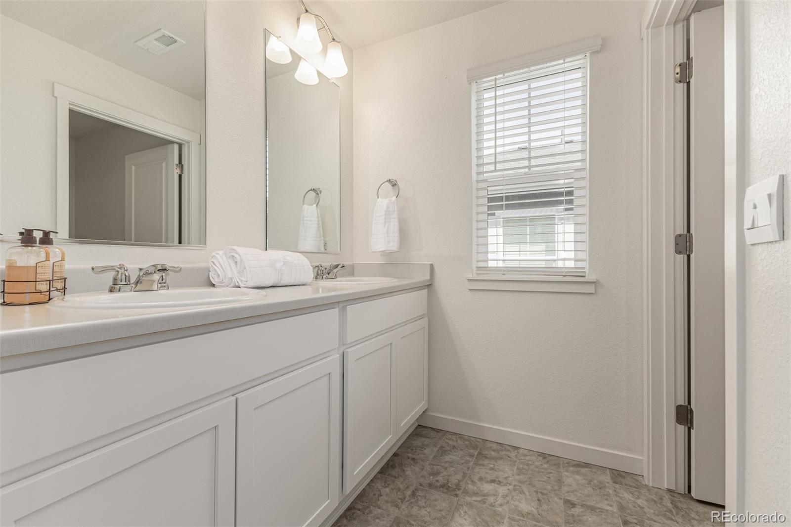 773 Allium Street Watkins, CO 80137 - Photo 27 of 46 a bathroom with a sink a vanity and a mirror