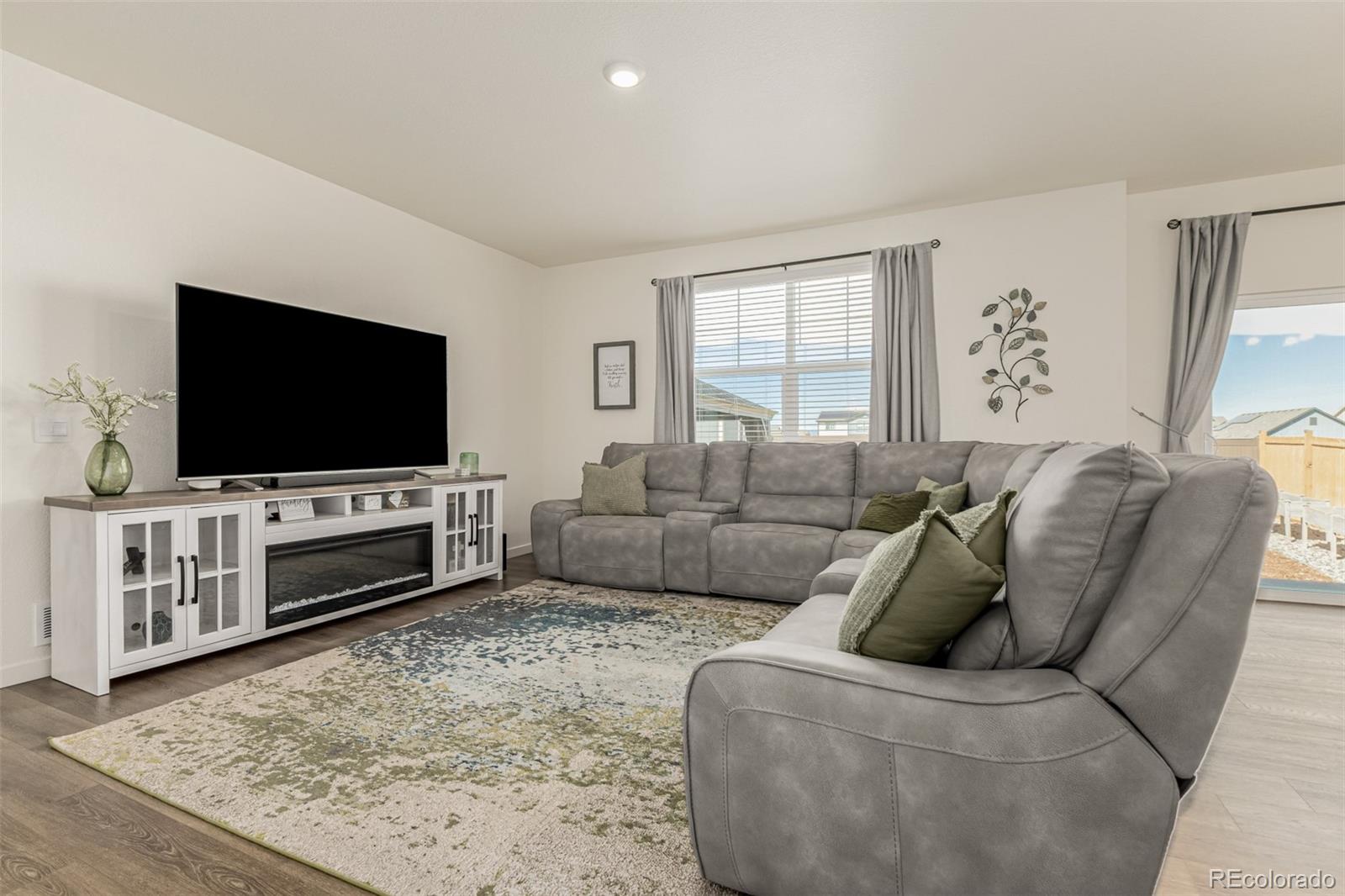 773 Allium Street Watkins, CO 80137 - Photo 10 of 46 a living room with furniture and a flat screen tv