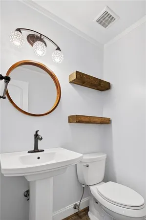 a bathroom with a toilet a sink and a mirror