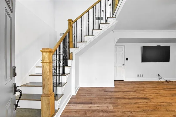 a view of entryway and hall with wooden floor