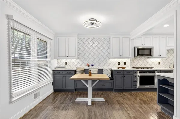 a kitchen with kitchen island granite countertop a sink cabinets and stainless steel appliances