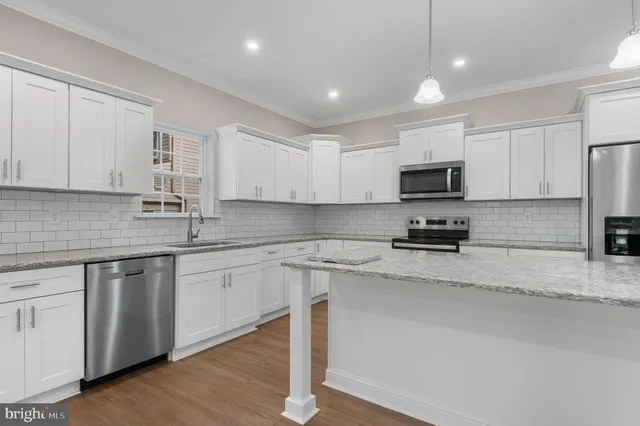 a kitchen with sink a microwave and cabinets