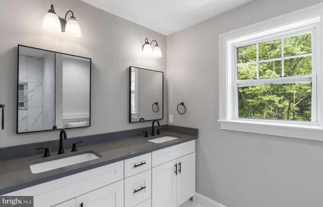 a bathroom with double vanity sinks and a mirror