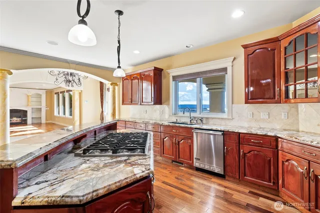a kitchen with stainless steel appliances granite countertop a stove and a wooden floors