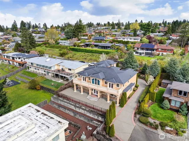 an aerial view of a house with garden space and a building