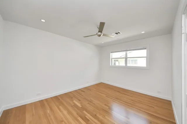 a view of a big room with wooden floor and windows