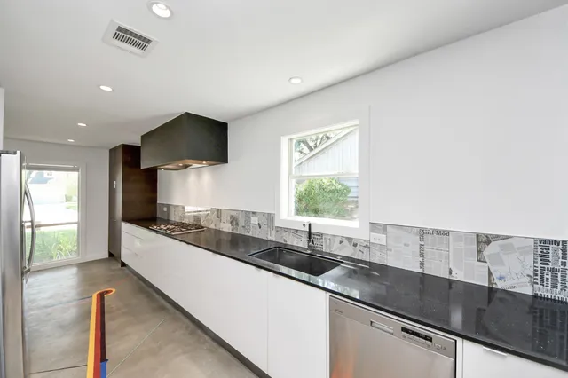 a large kitchen with a sink and a large window