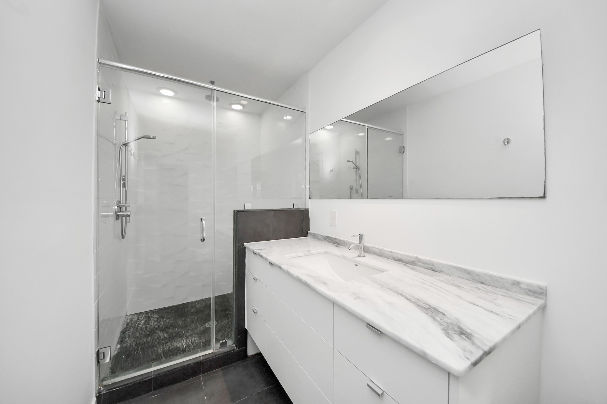 7610 Highmeadow Drive Houston, TX 77063 - Photo 35 of 50 a bathroom with a granite countertop sink a mirror and shower