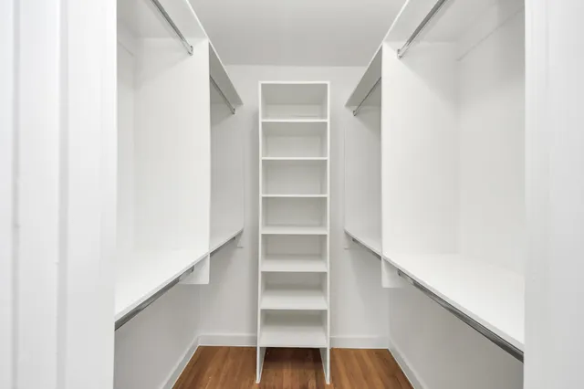 a view of a livingroom with a kitchen space and wooden floor