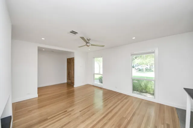 a view of a living room hardwood floor and a ceiling fan