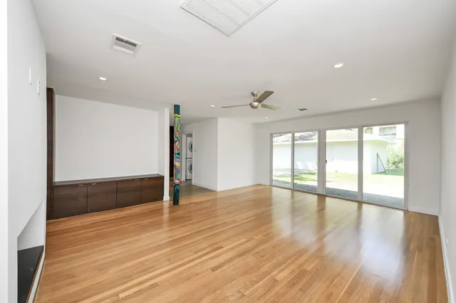 a view of a big room with wooden floor and windows