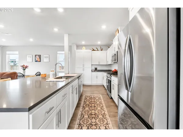 a kitchen with granite countertop white cabinets and white appliances