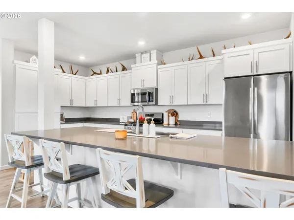 a kitchen with granite countertop white cabinets and stainless steel appliances