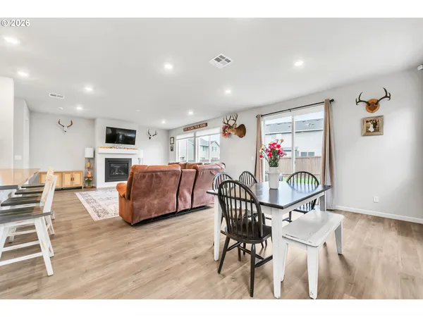 a view of a dining room with furniture wooden floor and a floor to ceiling window