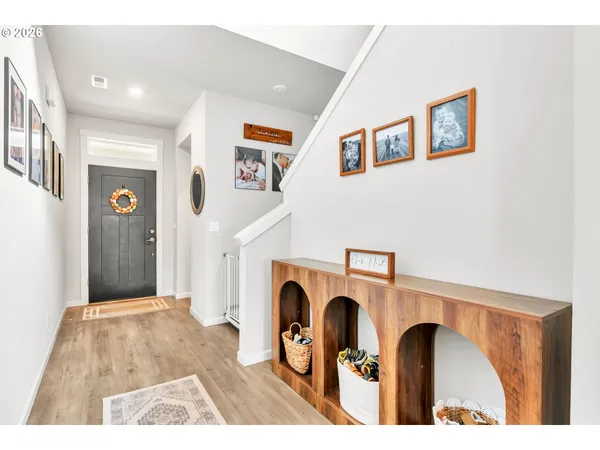 a view of a hallway with wooden floor and staircase
