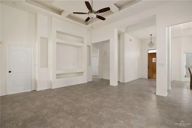 an empty room with closet and a ceiling fan