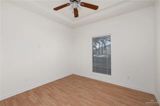 an empty room with a window and ceiling fan