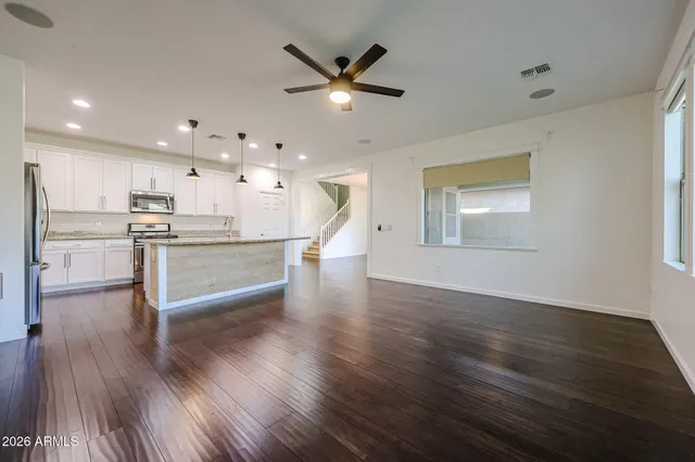 a view of a kitchen with wooden floor and a ceiling fan