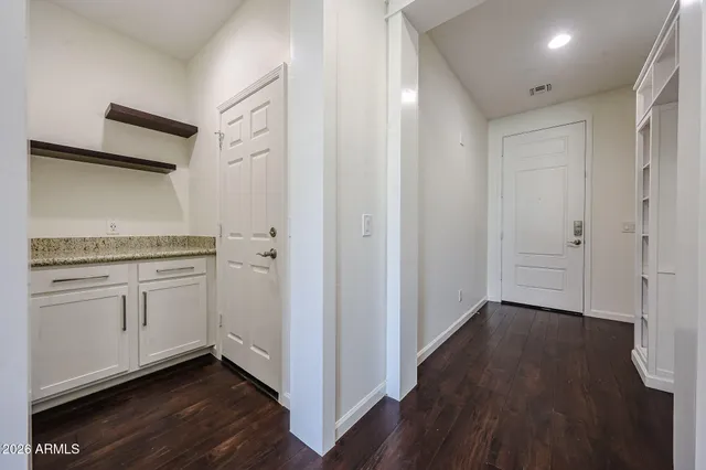 a hallway with wooden floors and white cabinet