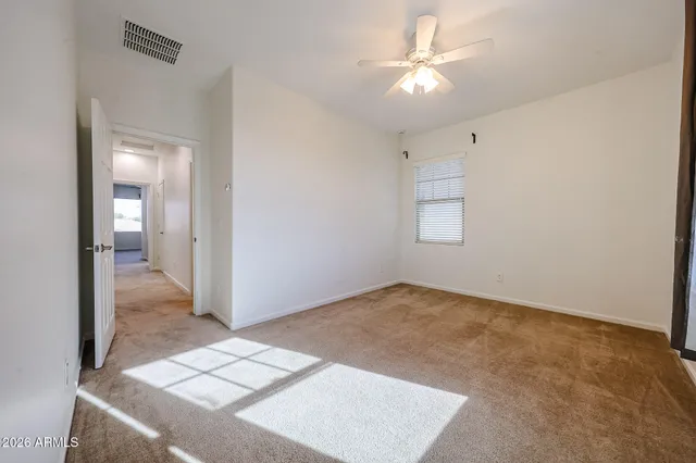an empty room with closet and a chandelier fan