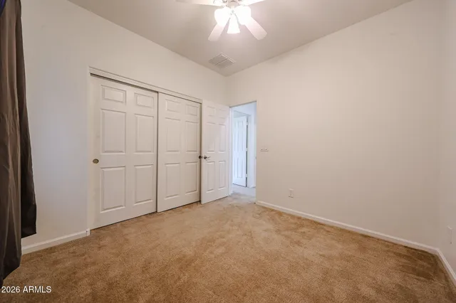 an empty room with a ceiling fan and entryway