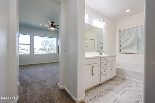 a bathroom with a granite countertop sink mirror and a bathtub