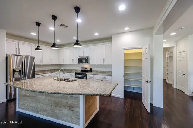 a kitchen with stainless steel appliances granite countertop a sink refrigerator and cabinets