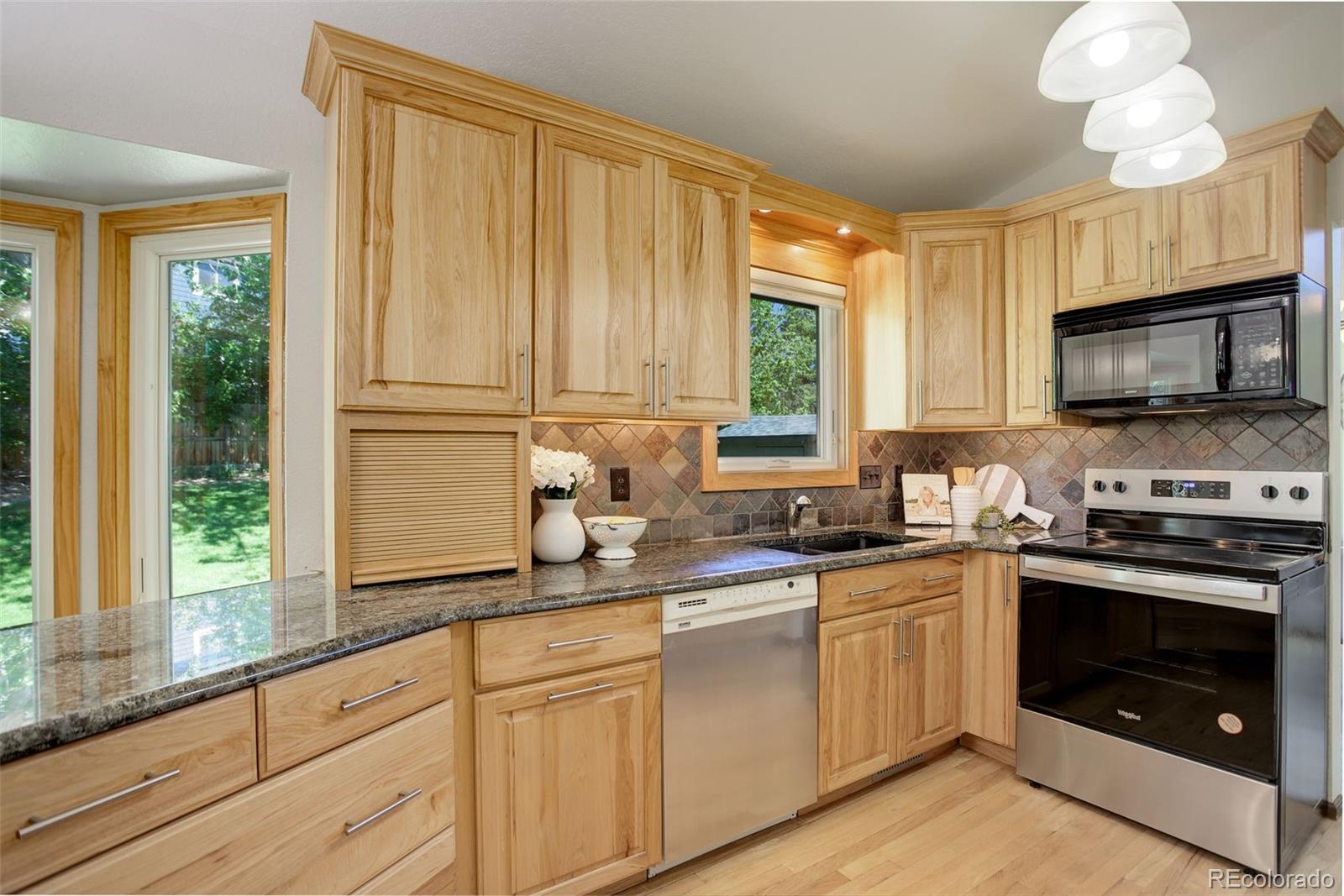 7877 West 110th Drive Westminster, CO 80021 - Photo 11 of 46 a kitchen with a sink stove and microwave