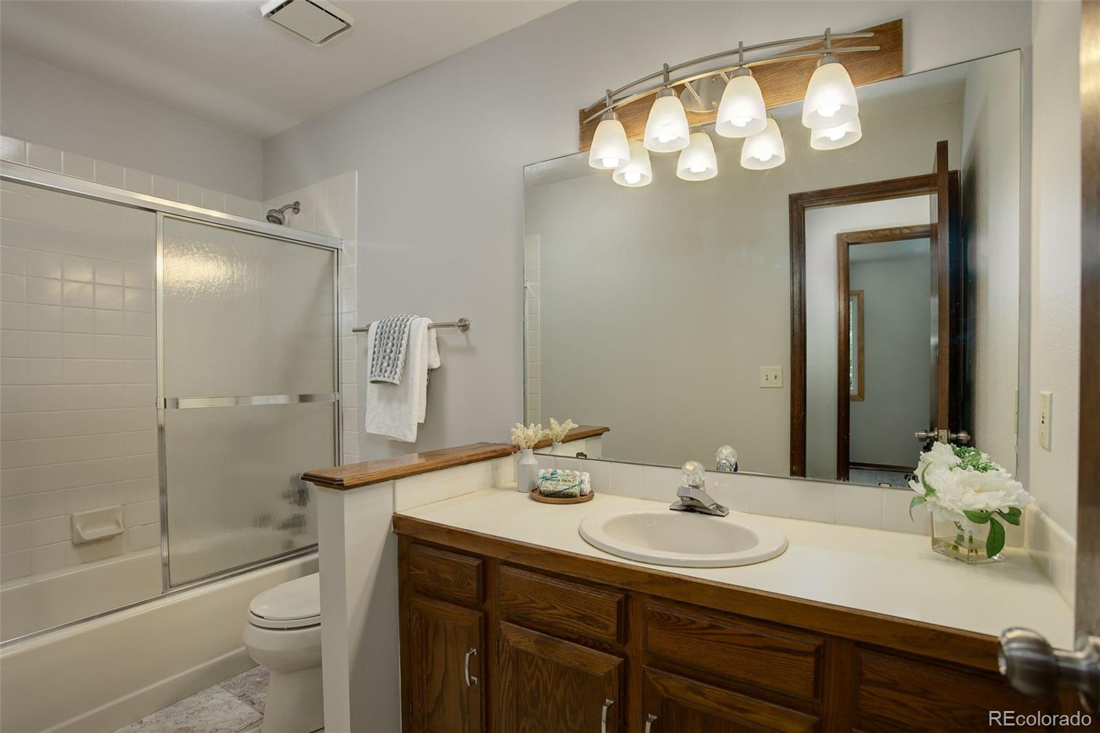 7877 West 110th Drive Westminster, CO 80021 - Photo 28 of 46 a bathroom with a sink a toilet and shower a mirror