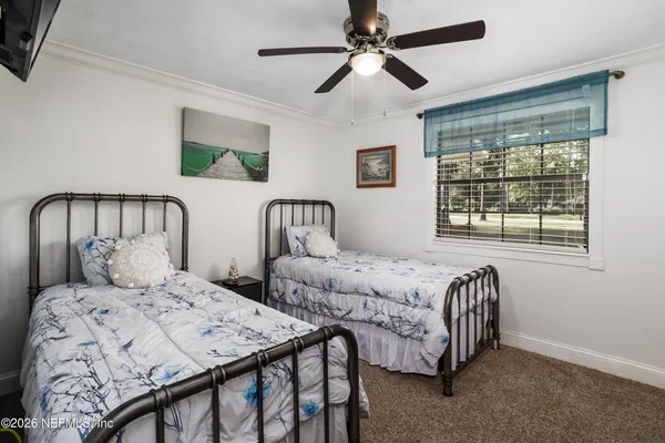 a bedroom with two beds and a large window