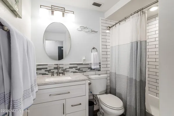 a bathroom with a sink mirror toilet and shower