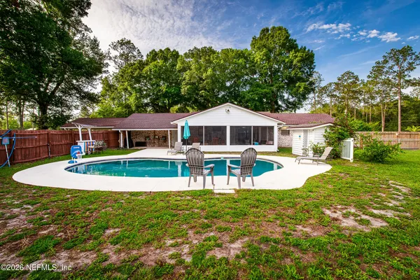 a view of a house with a yard patio and swimming pool