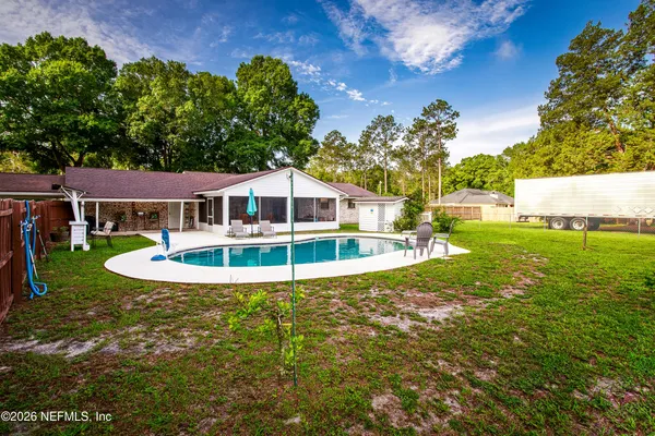 a view of a house with swimming pool and a yard