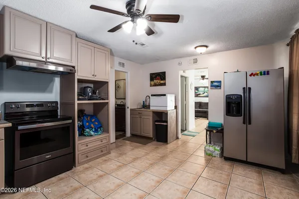 a kitchen with stainless steel appliances granite countertop a refrigerator a stove and a sink