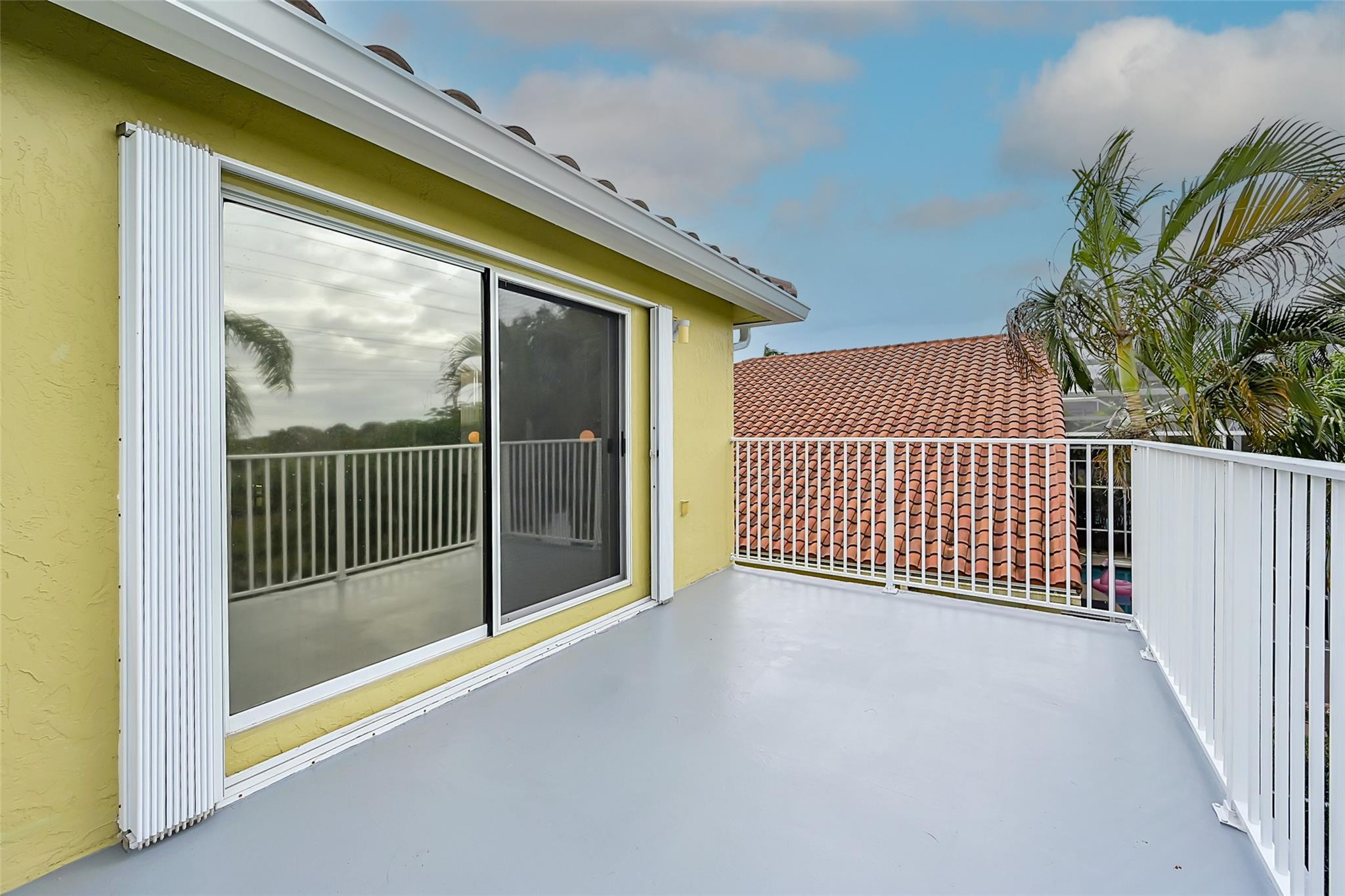 19640 Dinner Key Drive Boca Raton, FL 33498 - Photo 26 of 44 a view of a balcony with a floor to ceiling window and wooden fence
