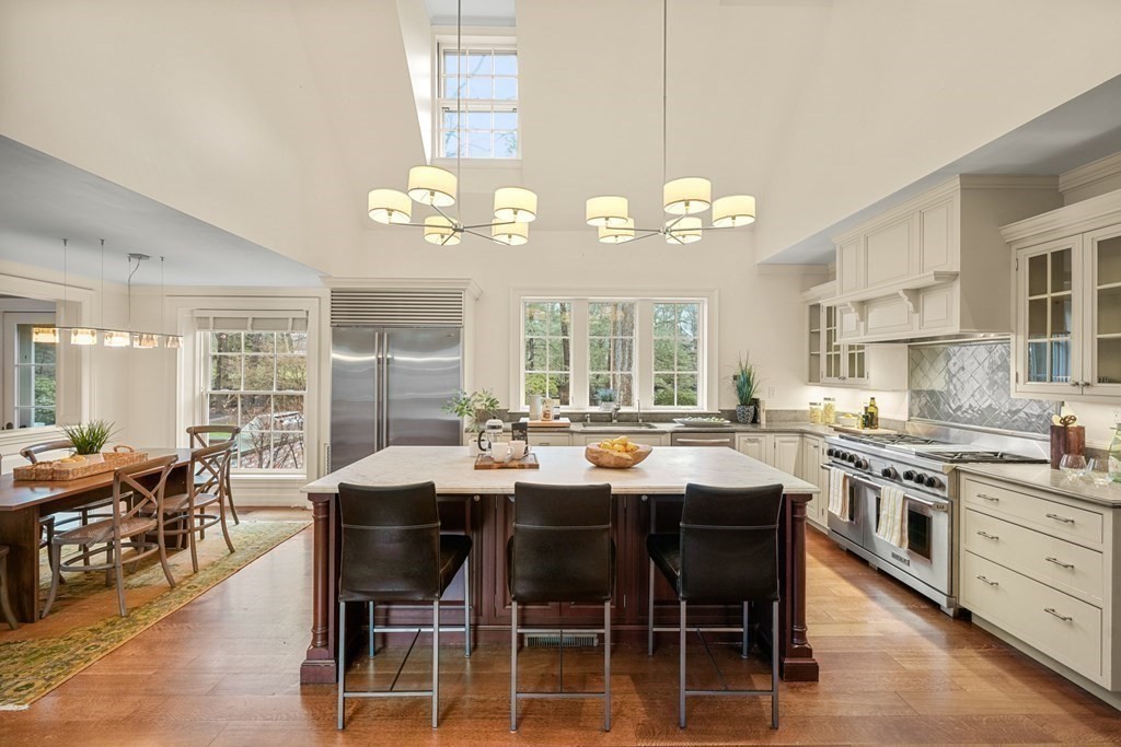 20 Sears Road Brookline, MA 02445 - Photo 12 of 40 a dining table with chairs kitchen island granite countertop wooden floor cabinets and stainless steel appliances