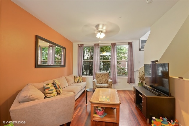 1244 West Monroe Street, Unit 7 Chicago, IL 60607 - Photo 2 of 12 a living room with furniture a large window and a flat screen tv