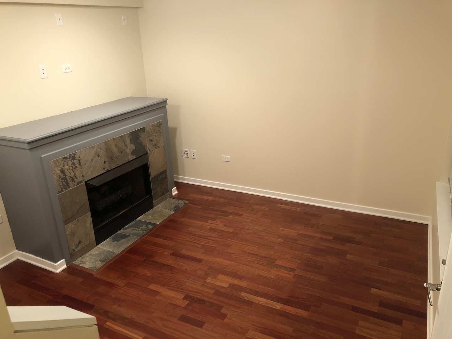 1244 West Monroe Street, Unit 7 Chicago, IL 60607 - Photo 8 of 12 a view of an empty room with wooden floor and a fireplace