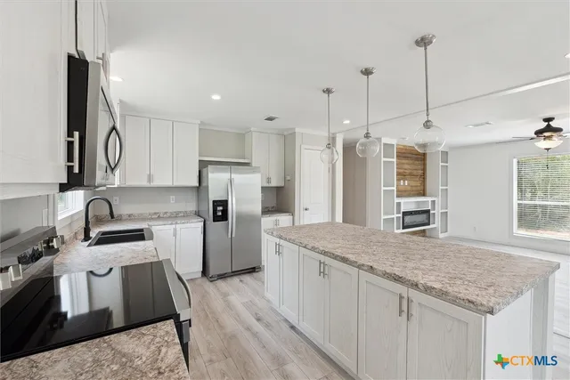 a kitchen with a sink refrigerator and microwave
