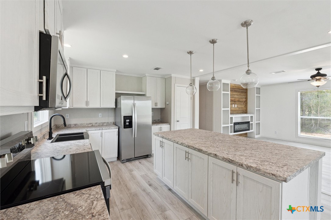 855 Roosevelt Road Luling, TX 78648 - Photo 13 of 47 a kitchen with a sink refrigerator and microwave