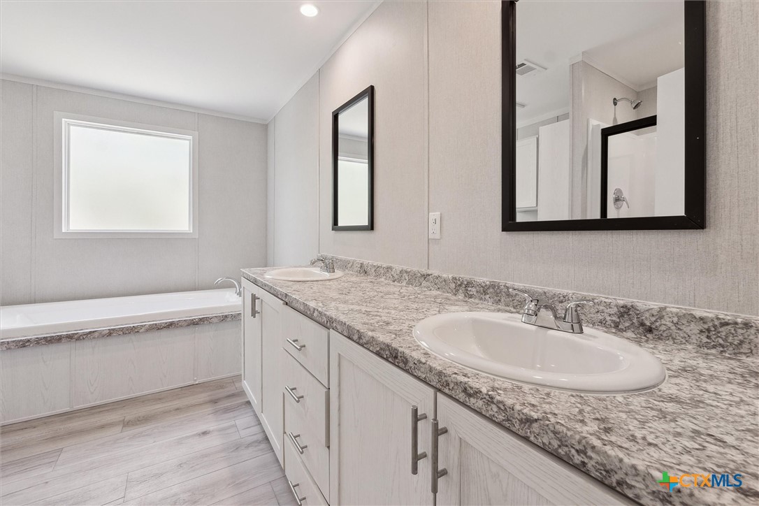 855 Roosevelt Road Luling, TX 78648 - Photo 20 of 47 a bathroom with a granite countertop sink and a mirror
