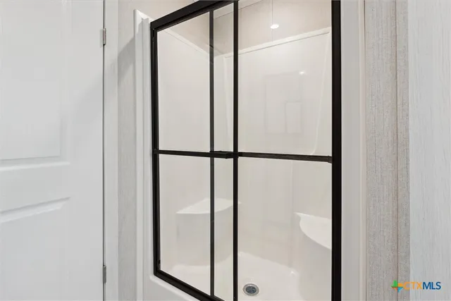 a bathroom with a glass shower door